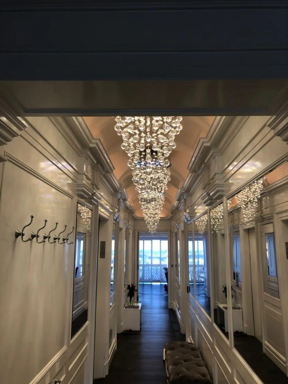 Paneled hallway lit by crystal chandeliers