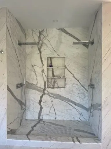 Marble walk-in shower with a built-in niche